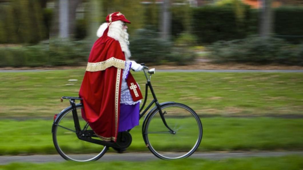 een afbeelding van een fietsende sinterklaas