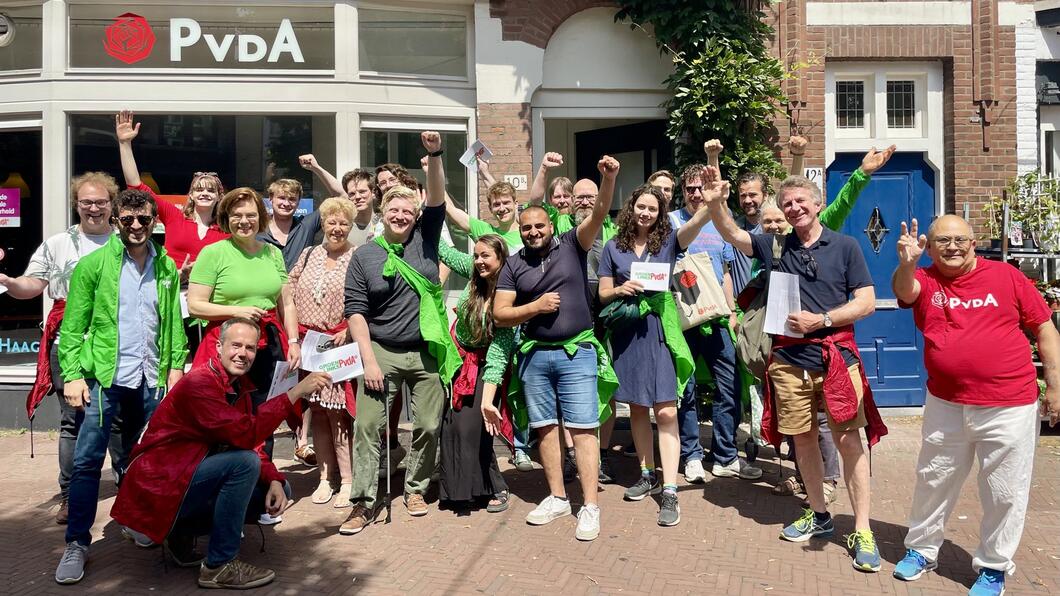 Groep vrijwilligers in groene en rode partijkleding