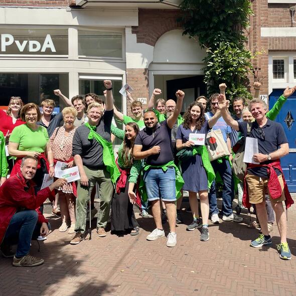 Groep vrijwilligers in groene en rode partijkleding