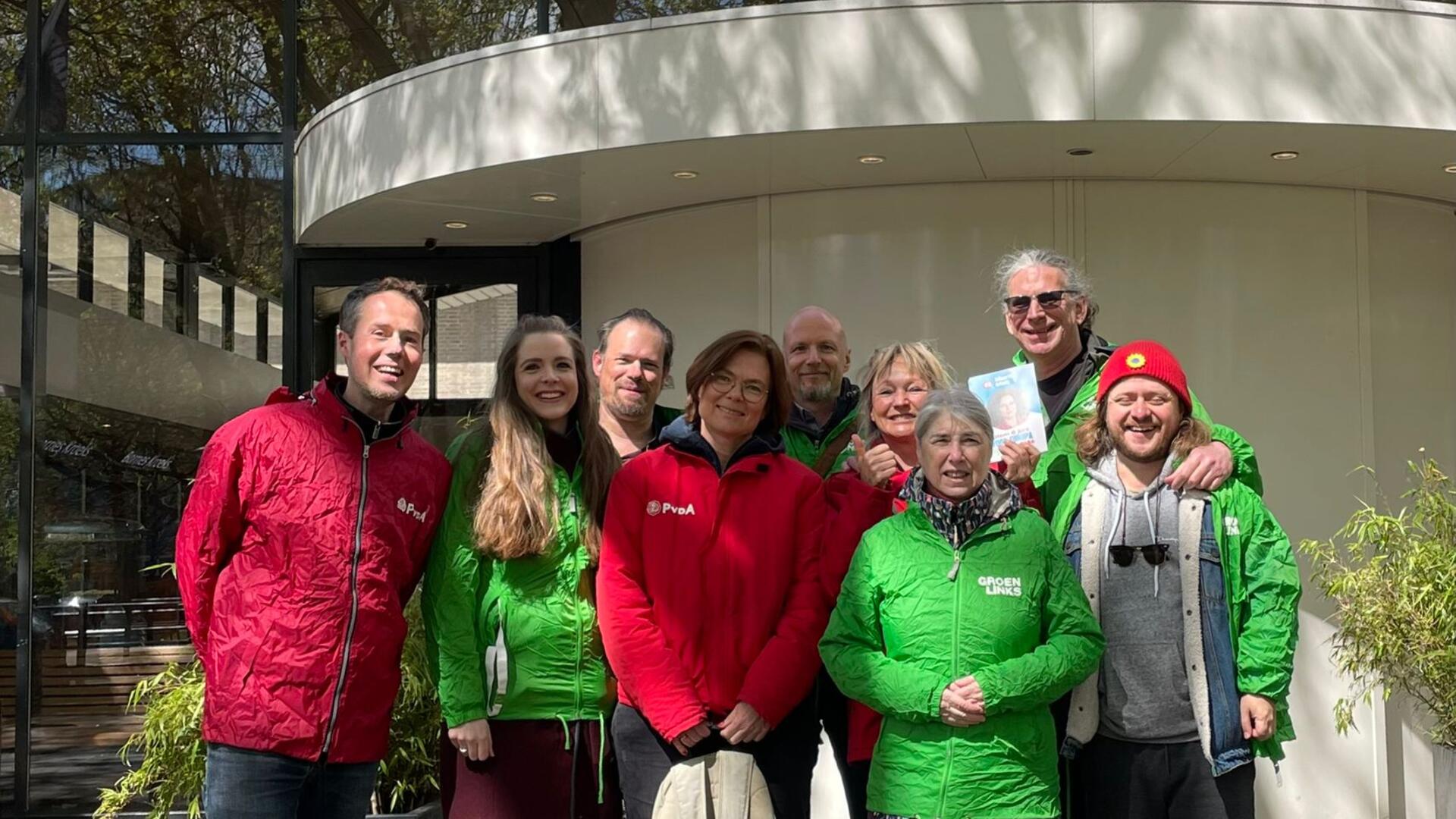 Groep campagnevrijwilligers in groene en rode jasjes